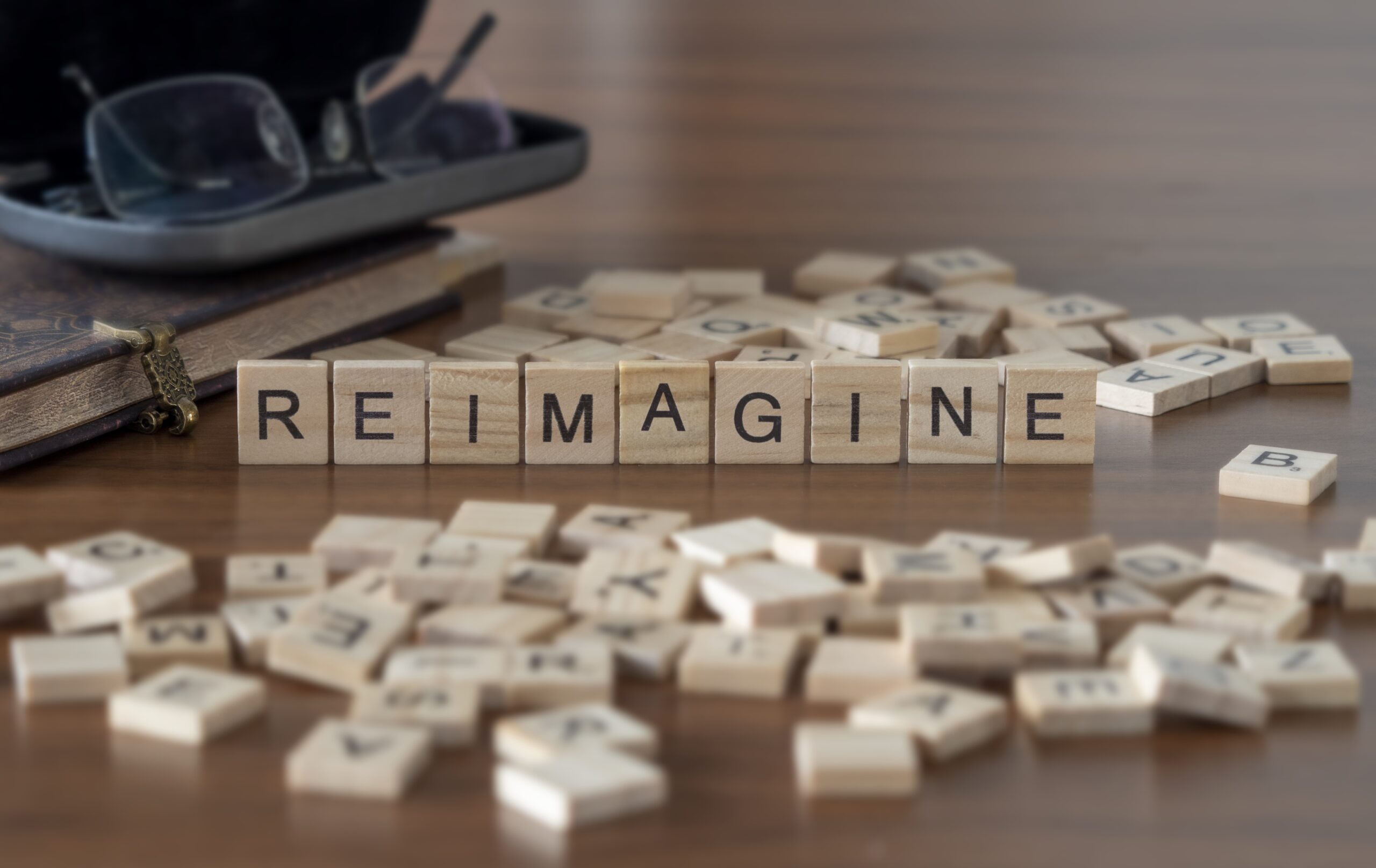 The concept of Reimagine represented by wooden letter tiles